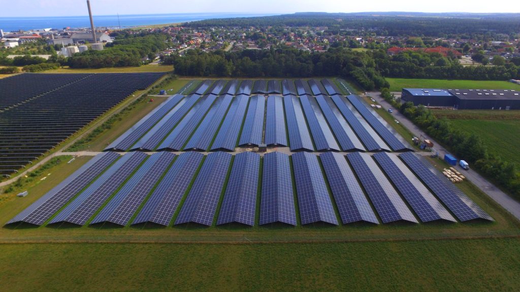 Aerial photo of the Grenaa solar power plant in Denmark with coastal background and photovoltaic panels