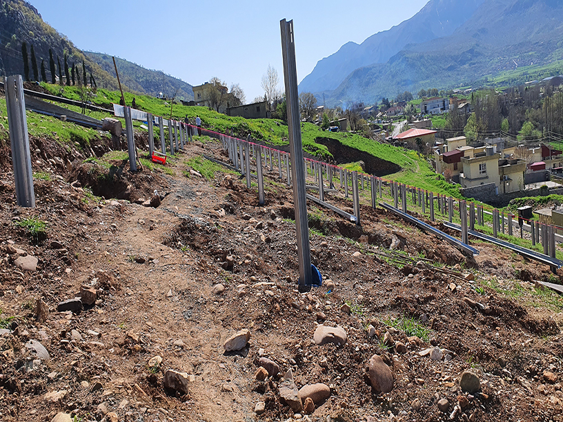 Steel foundation posts installed on steep, rocky terrain for the Rezan Solar Project in Iraq