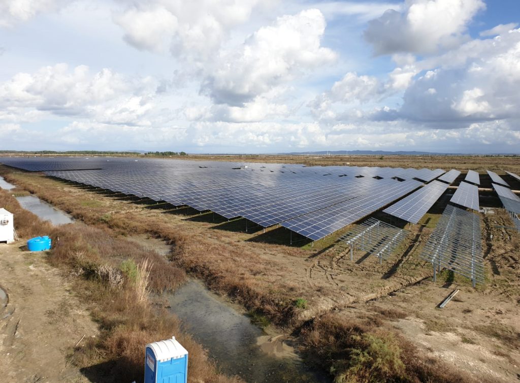 Aerial view of the solar park in Fier, Albania, showing rows of photovoltaic panels producing renewable energy under a cloudy sky