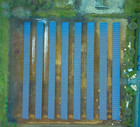 Luftaufnahme des Solarparks Neu-Kaliss mit gleichmäßig angeordneten Solarmodulen auf einer rechteckigen Fläche