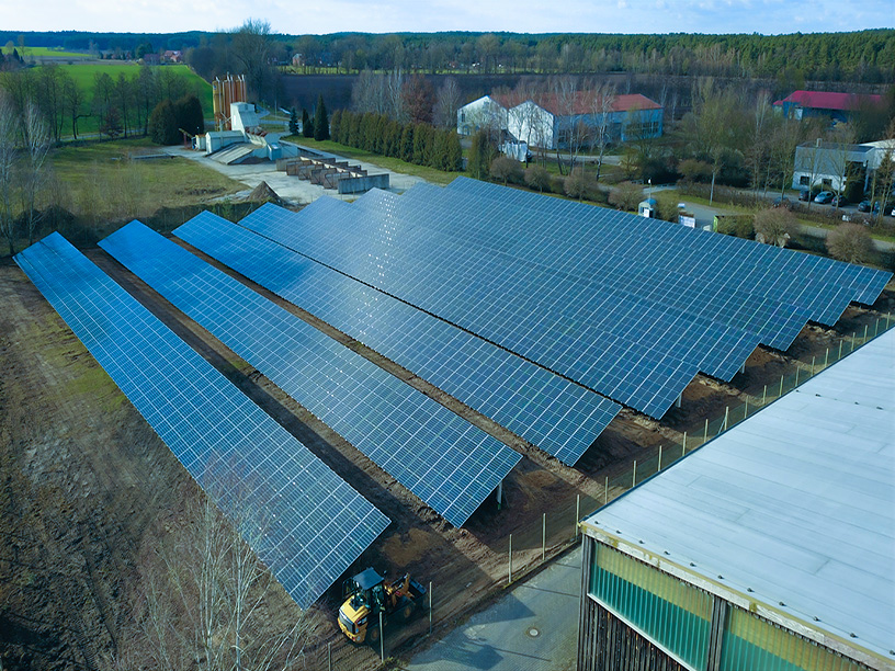 Photovoltaikanlage im Solarpark Neu-Kaliss mit installierten Solarmodulen und Baumaschine im Vordergrund