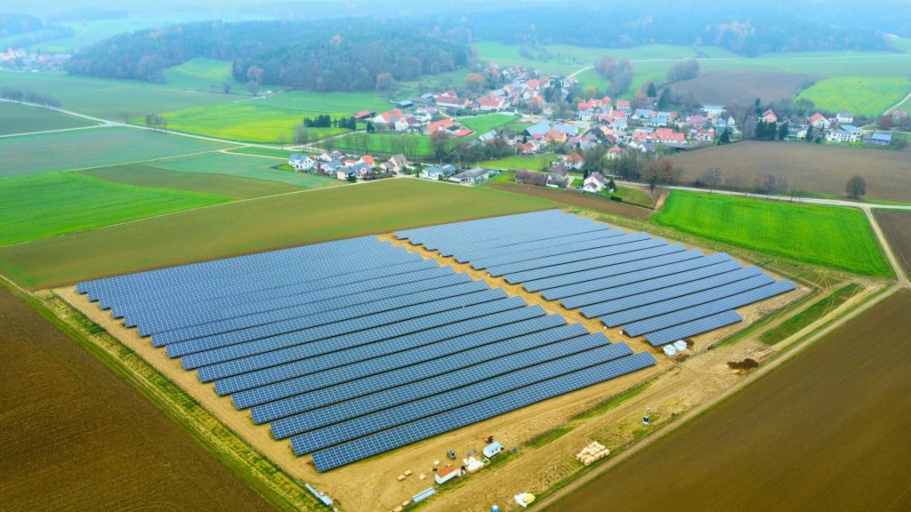 Luftaufnahme des Solarparks Osterzhausen mit großflächig installierten Solarmodulen in Bayern