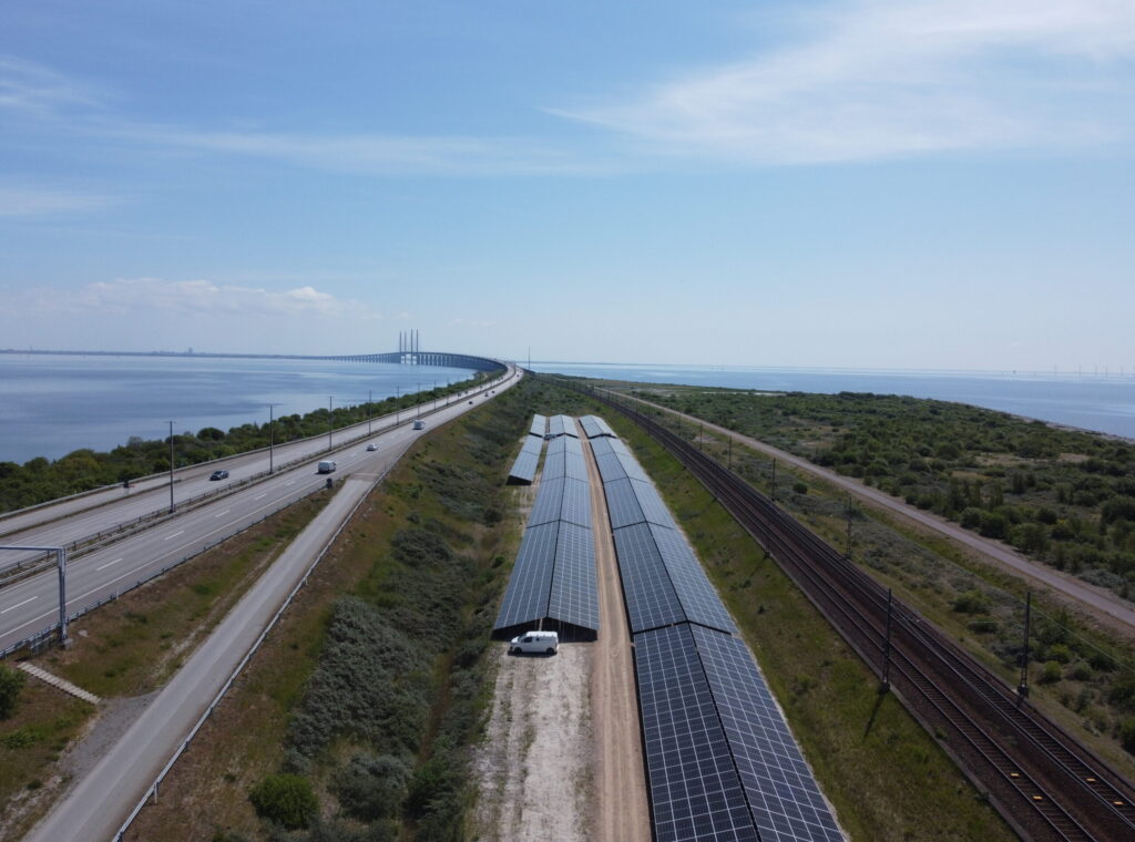 Aerial view of the Peberholm solar project in Denmark next to the Øresund Bridge and railway