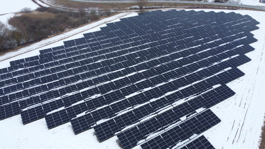 Seitliche Ansicht der Photovoltaik-Anlage im Solarpark Metten in Deutschland mit stabiler Unterkonstruktion und winterlicher Landschaft